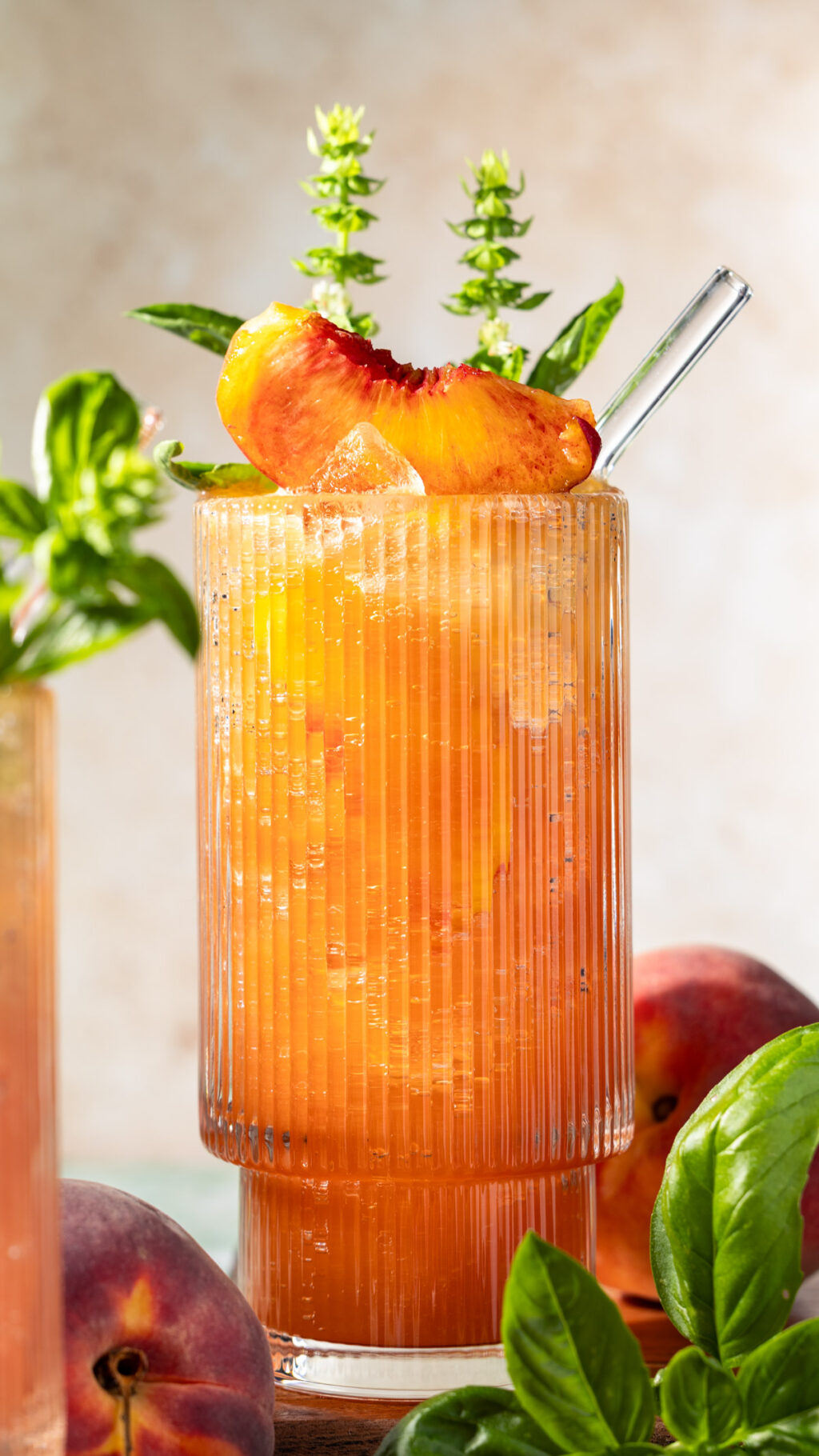 Peach Basil Highball made with bourbon, peaches, honey, lemon juice, and fresh basil. Topped off with sparkling water for a refreshing summer cocktail!