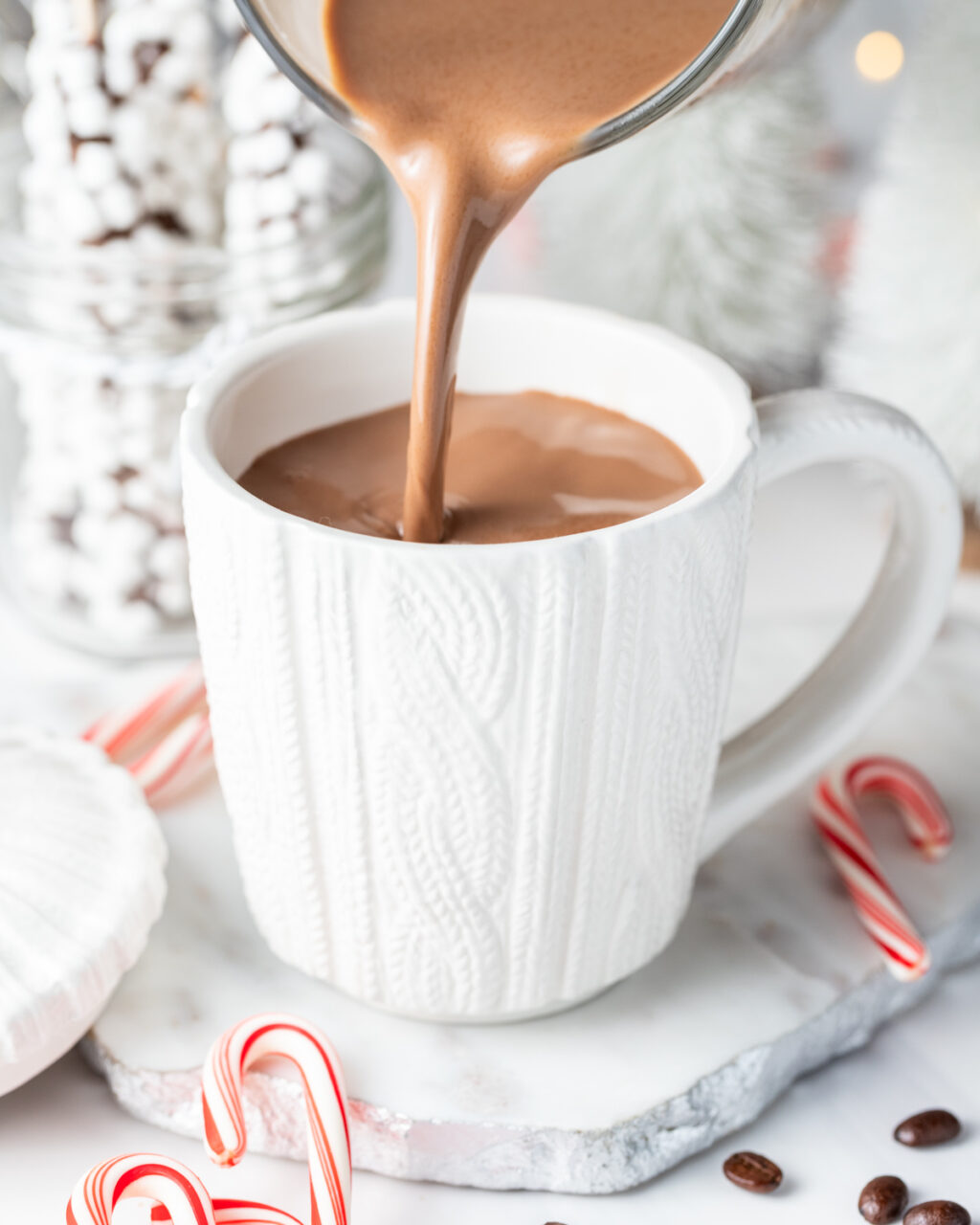 Slow Cooker Peppermint Mocha Hot Chocolate being poured into a white mug.