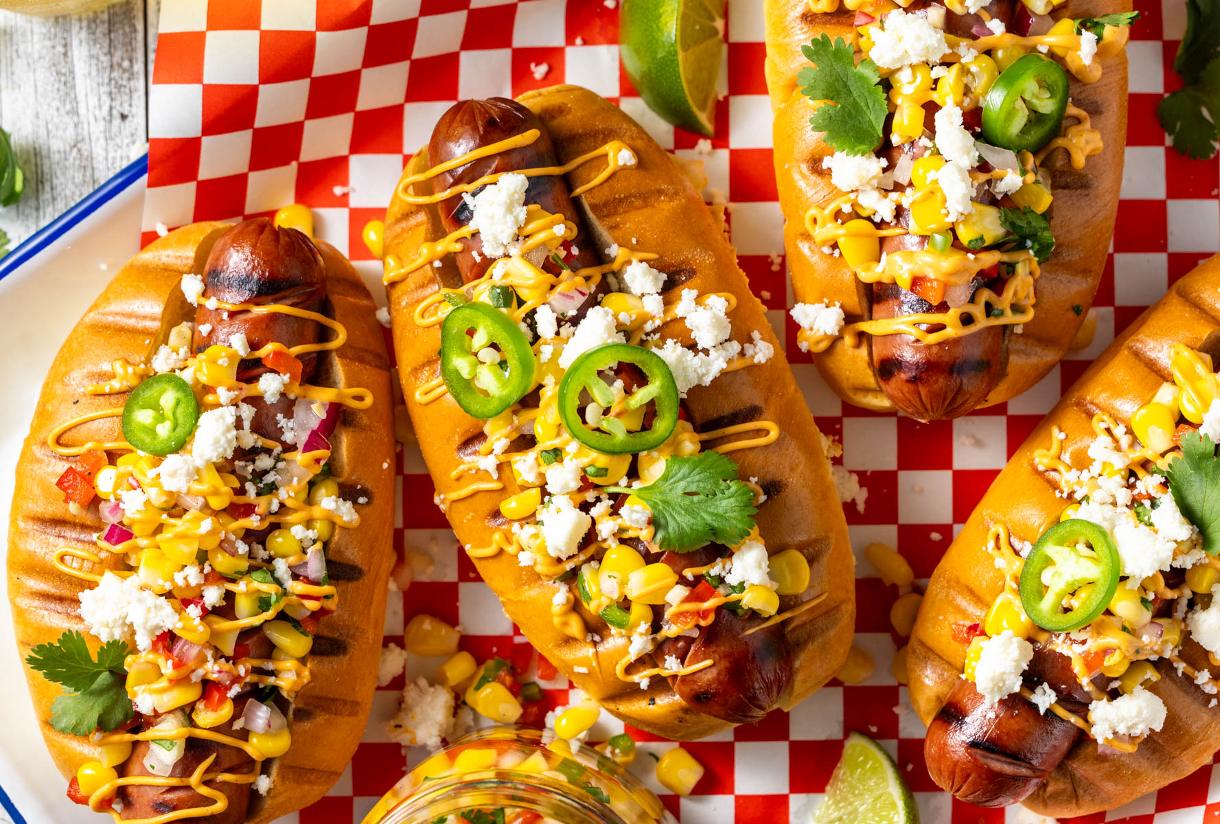Grilled hot dogs with pickled corn relish, chipotle mayo, and queso fresco. Grill these up for your next barbecue - a great meal to share with friends!