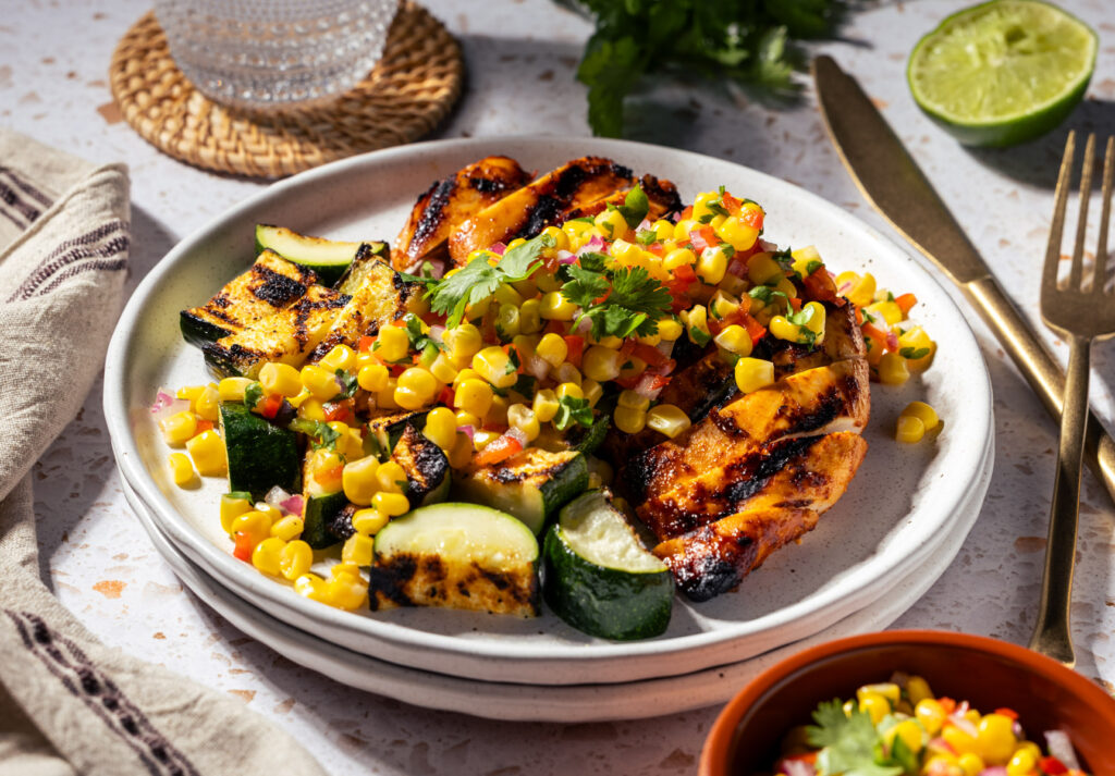 Grilled Adobo Chicken with Pickled Corn Relish and grilled zucchini. Perfect for your next barbecue or meal prep!