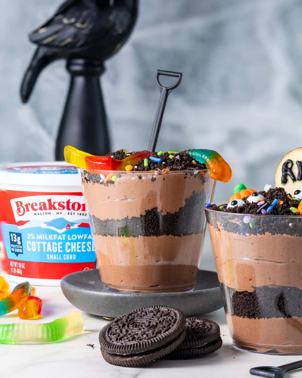 Cottage cheese dirt pudding cups with gummy worms, sprinkles, and eyeball candies.